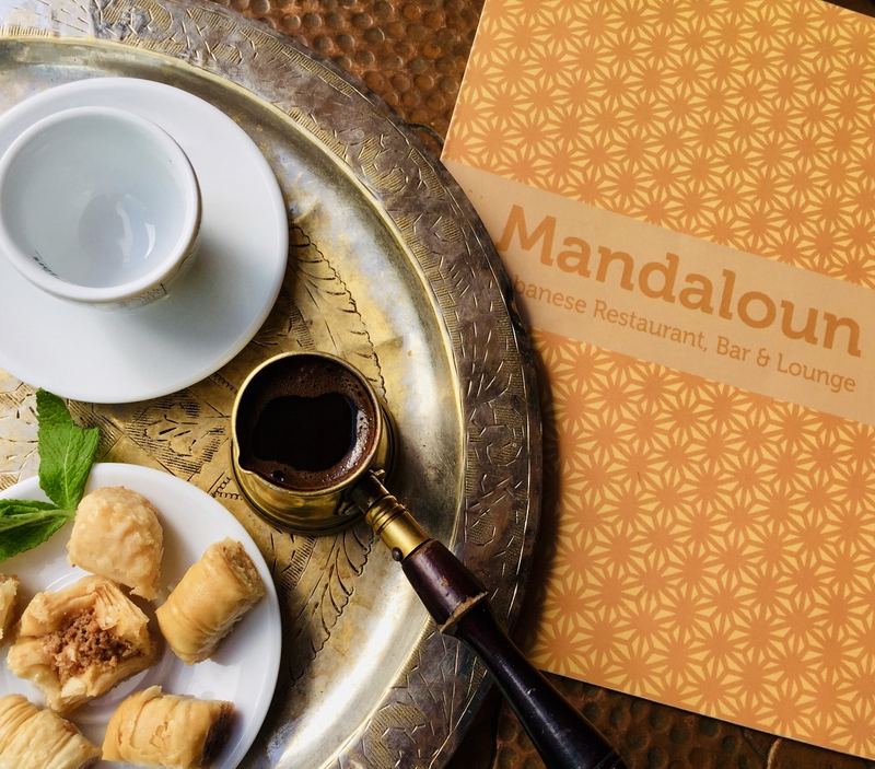 Lebanese coffee in a cezve with baklawa on a brass tray