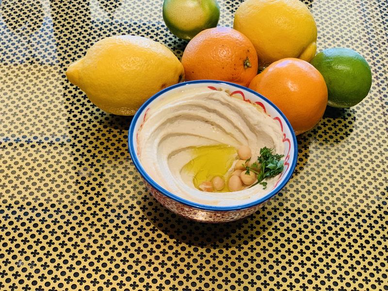 Houmous in a hand-painted bowl with citrus fruit