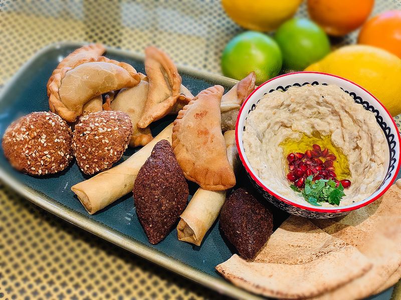 Kebbeh, sambousek and spring rolls beside baba ghanouj