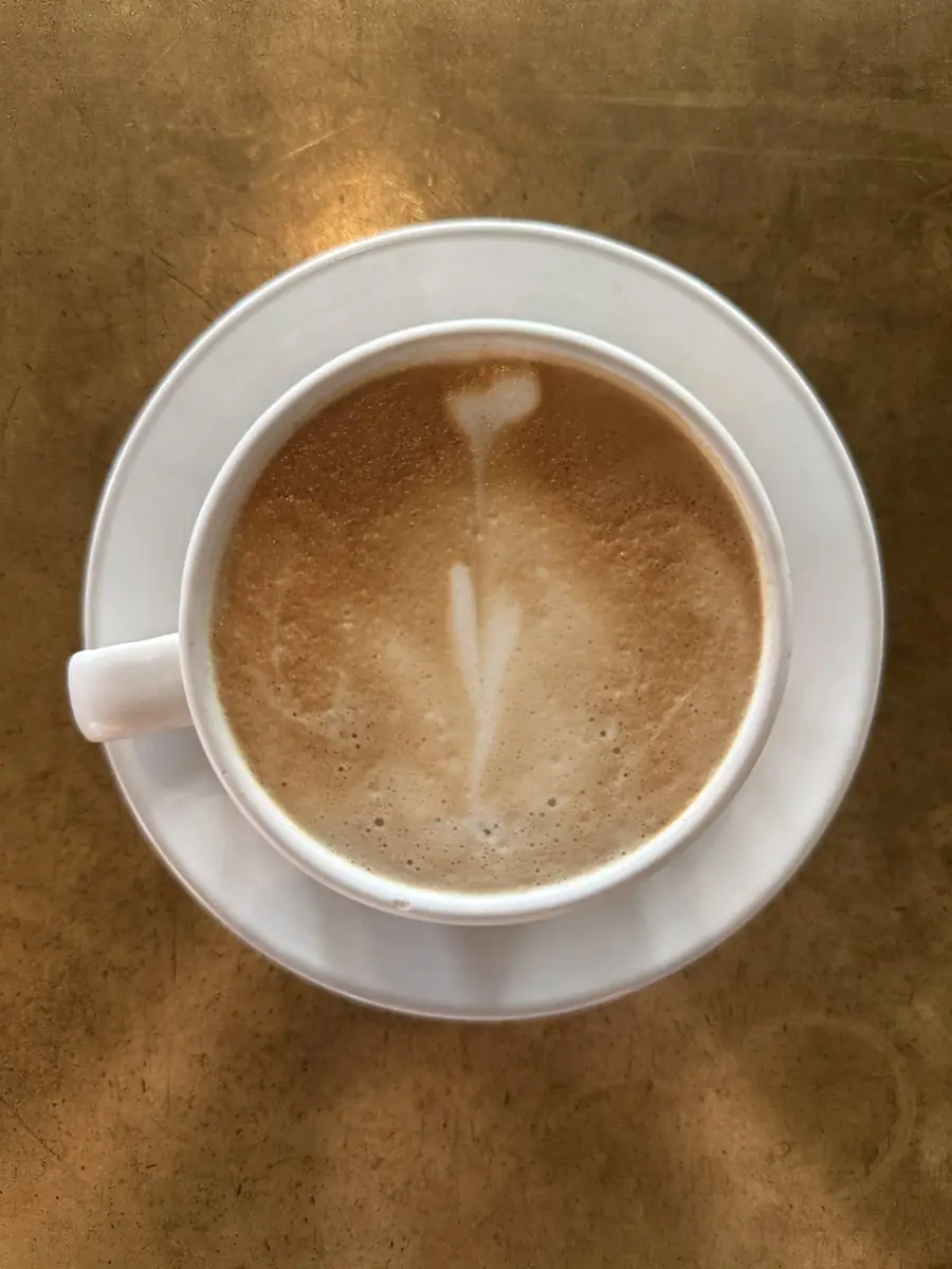 Coffee at The Reach Riverside: a cappuccino with a leaf of milk foam, seen from above